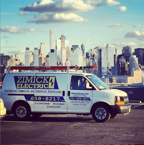 An early Zimick Electric service van photographed against the Manhattan skyline