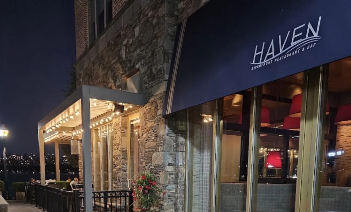 HAVEN Riverfront Restaurant and Bar at night with lit pergola and Hudson River terrace