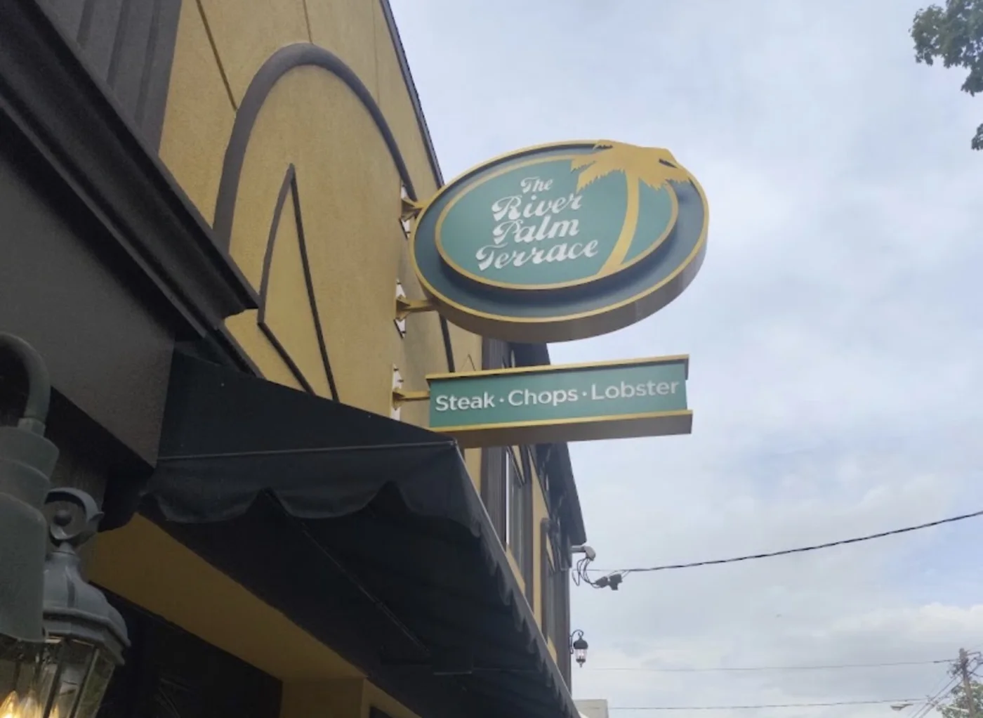The River Palm Terrace steakhouse blade sign and awning on River Road in Edgewater