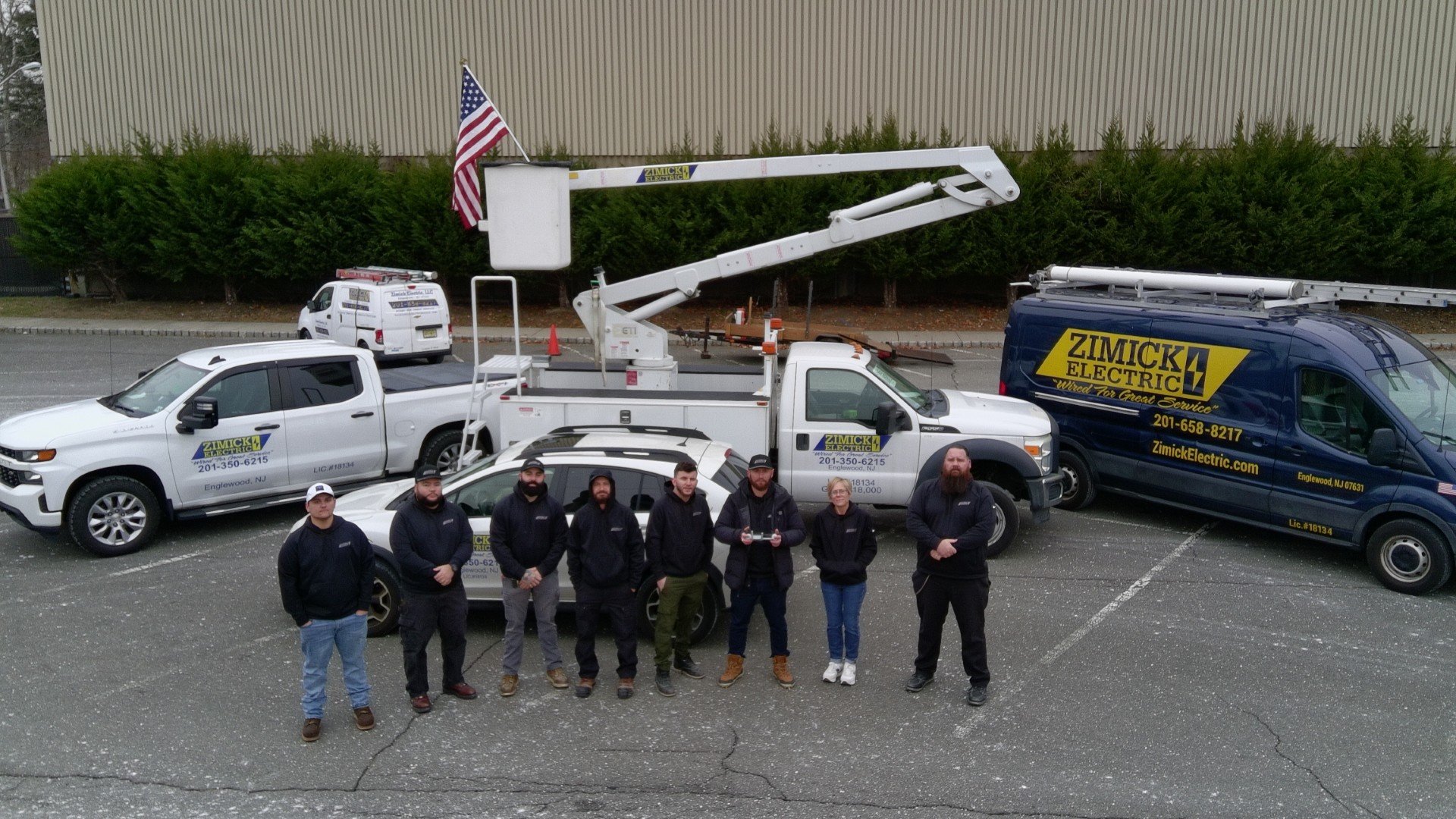 The Zimick Electric field team standing with the company service fleet including a bucket truck